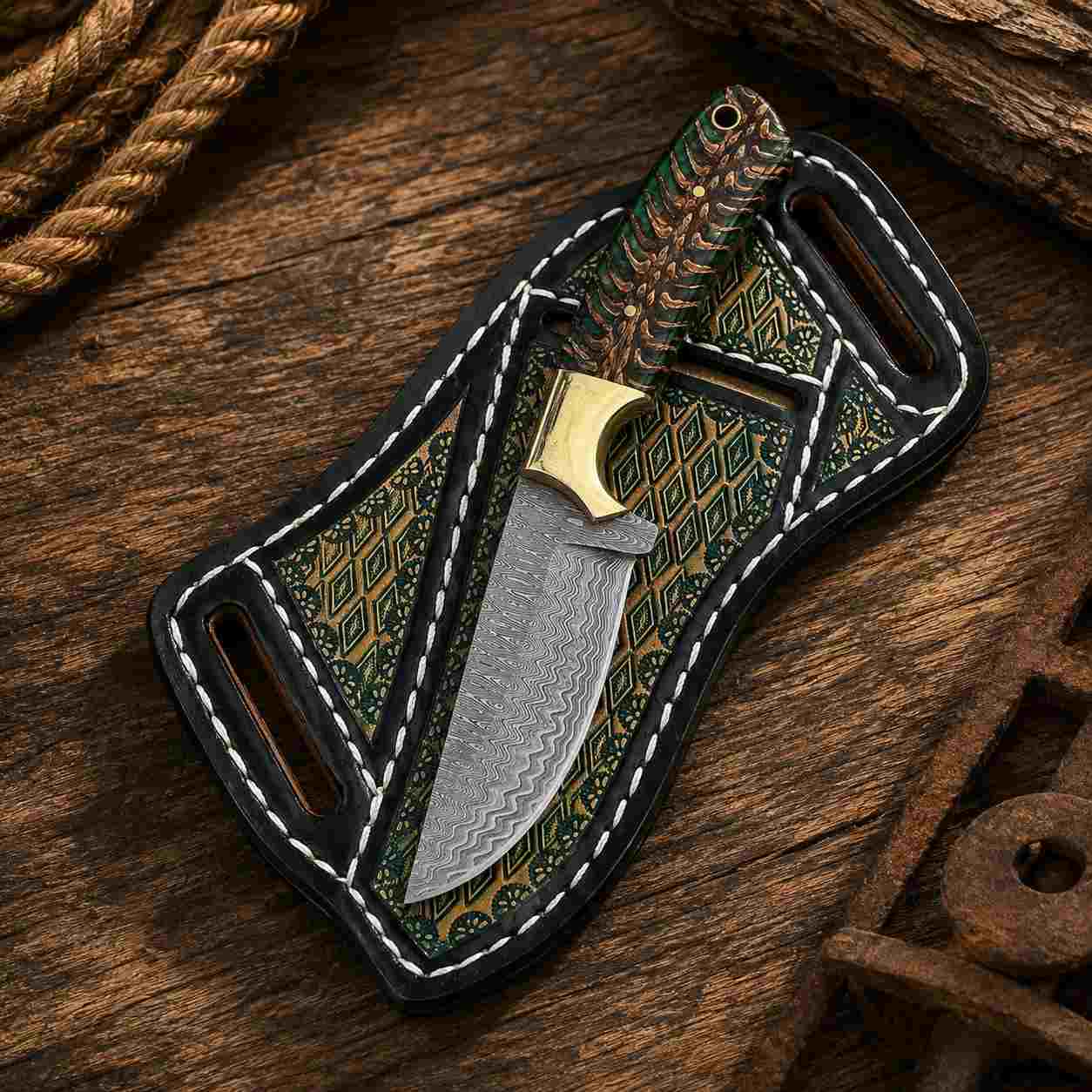 Damascus Buckaroo knife showing patterned blade and green pine cone handle with brass bolster