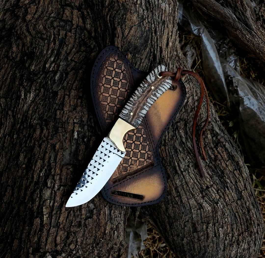 Rasp steel ranch knife with brass bolster and pine cone handle beside a crossdraw pancake sheath