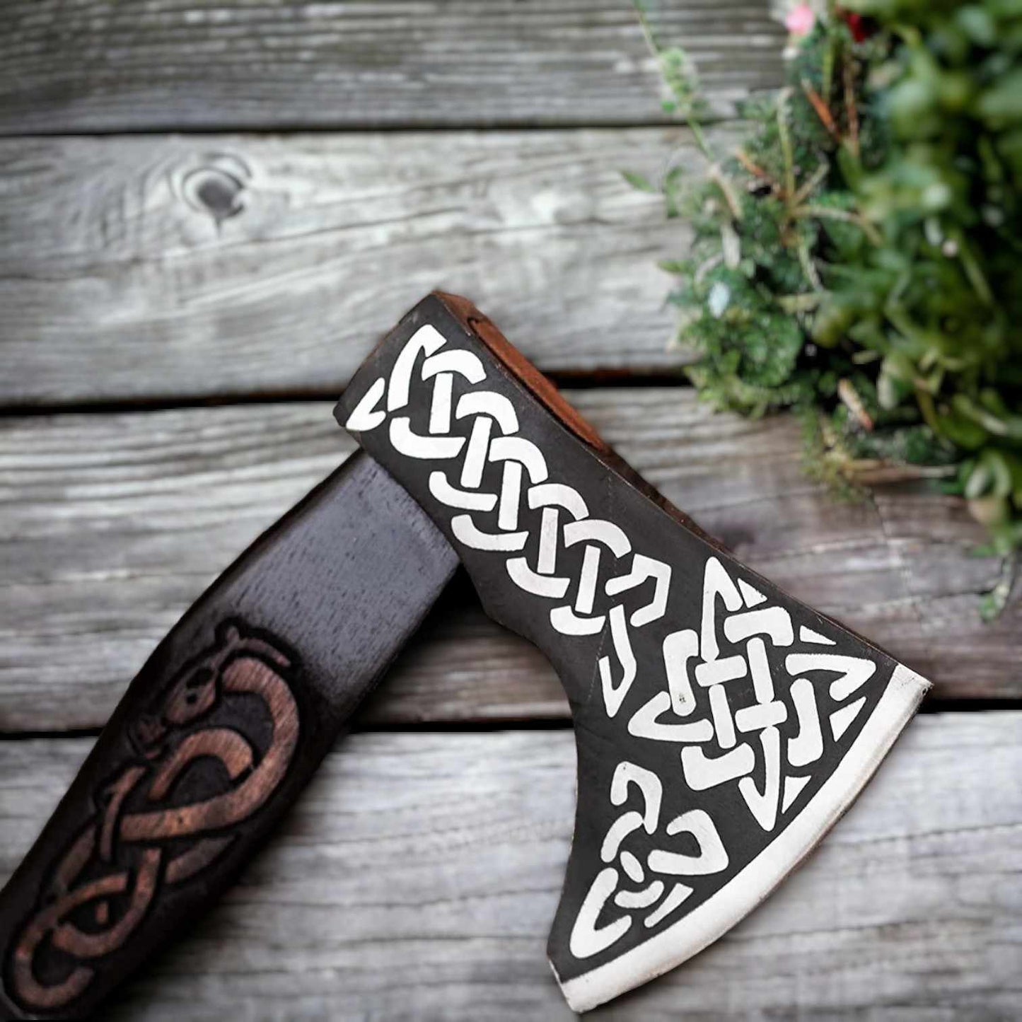 Close-up of Viking axe head showing Celtic knotwork engraving on carbon steel
