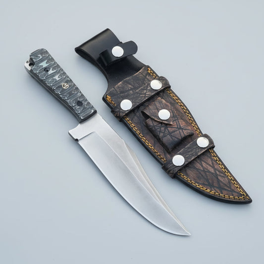 A Clip Point Bowie Knife with a G10 Micarta handle and D2 steel blade, accompanied by a Cowhide leather sheath.