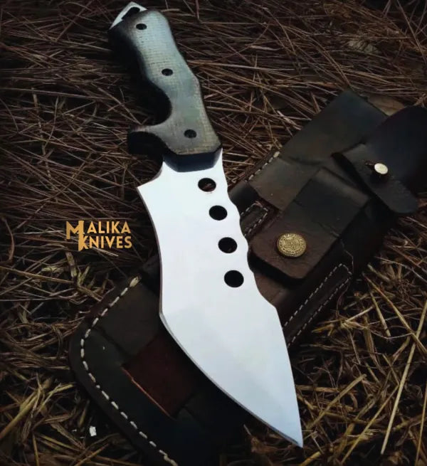 J2 tracker Knife with leather sheath on a textured surface, featuring 'Malika Knives' branding.