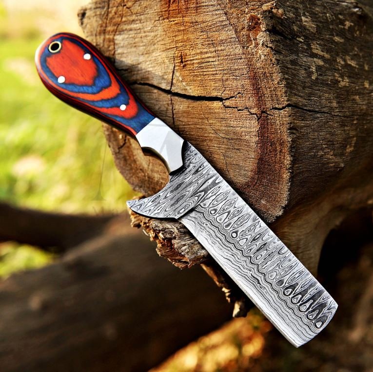 Damascus Bull CutterKnife with a red and blue handle on a wooden log