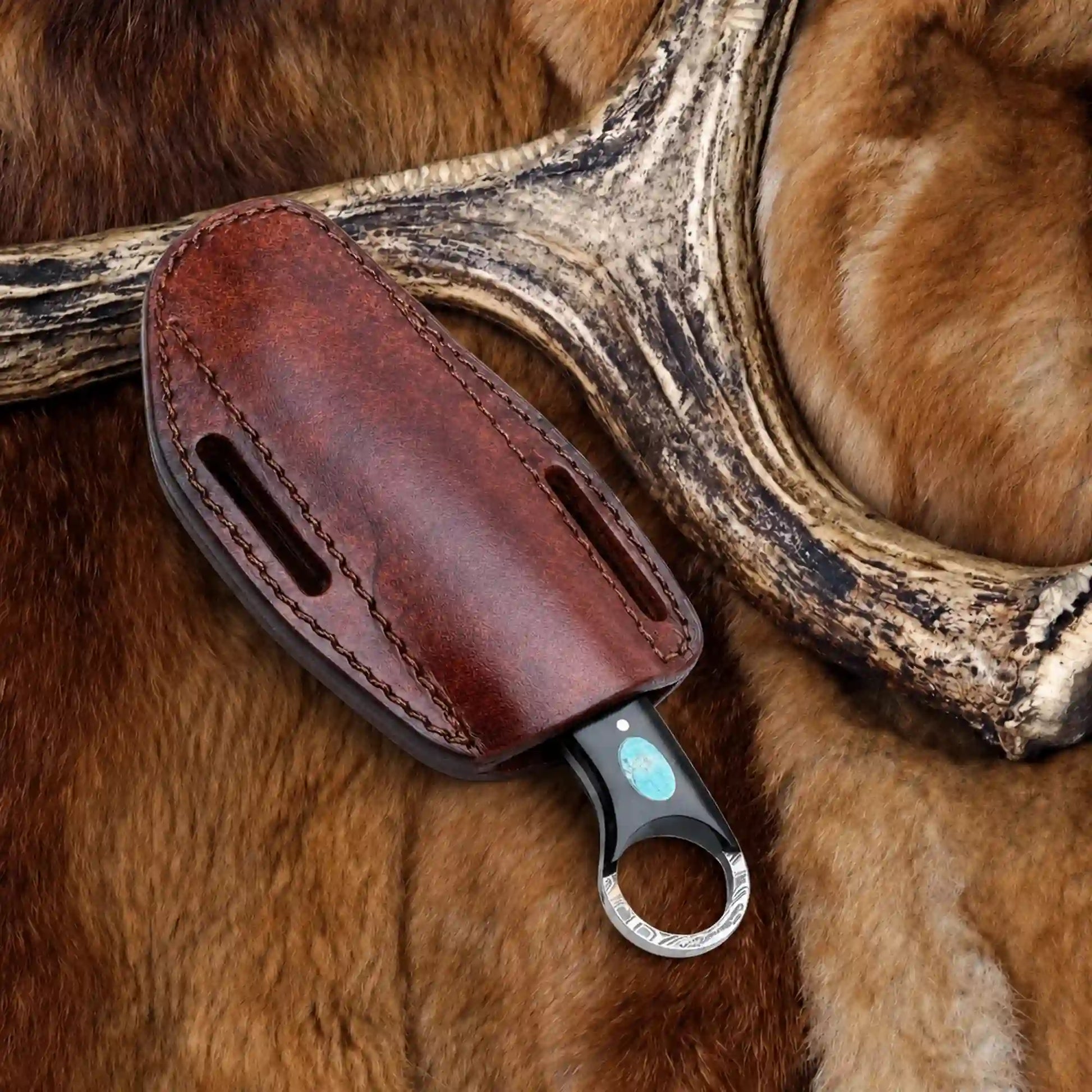 Pancake leather sheath with twin belt slots holding a copper damascus bull cutter knife with ring pommel