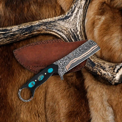 Copper damascus bull cutter blade showing copper layer lines and squared tip beside a brown leather sheath.