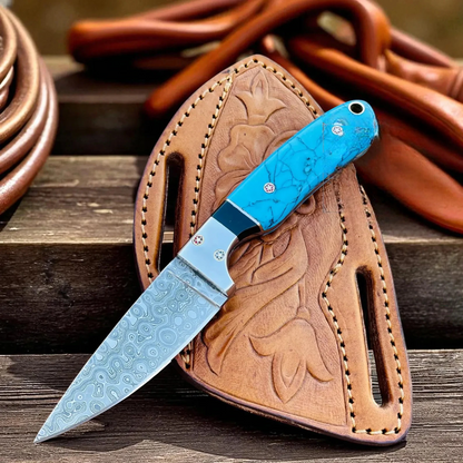 Cowboy Hunting Knife with blue Marble handle and brown Pancake leather sheath on a wooden surface