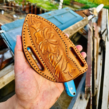 Hand holding a Pancake leather Sheath against a rustic background