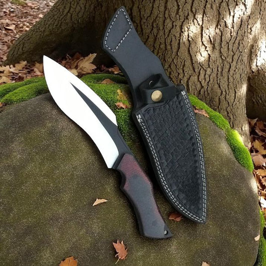 Knife with black sheath on a rock in a natural setting