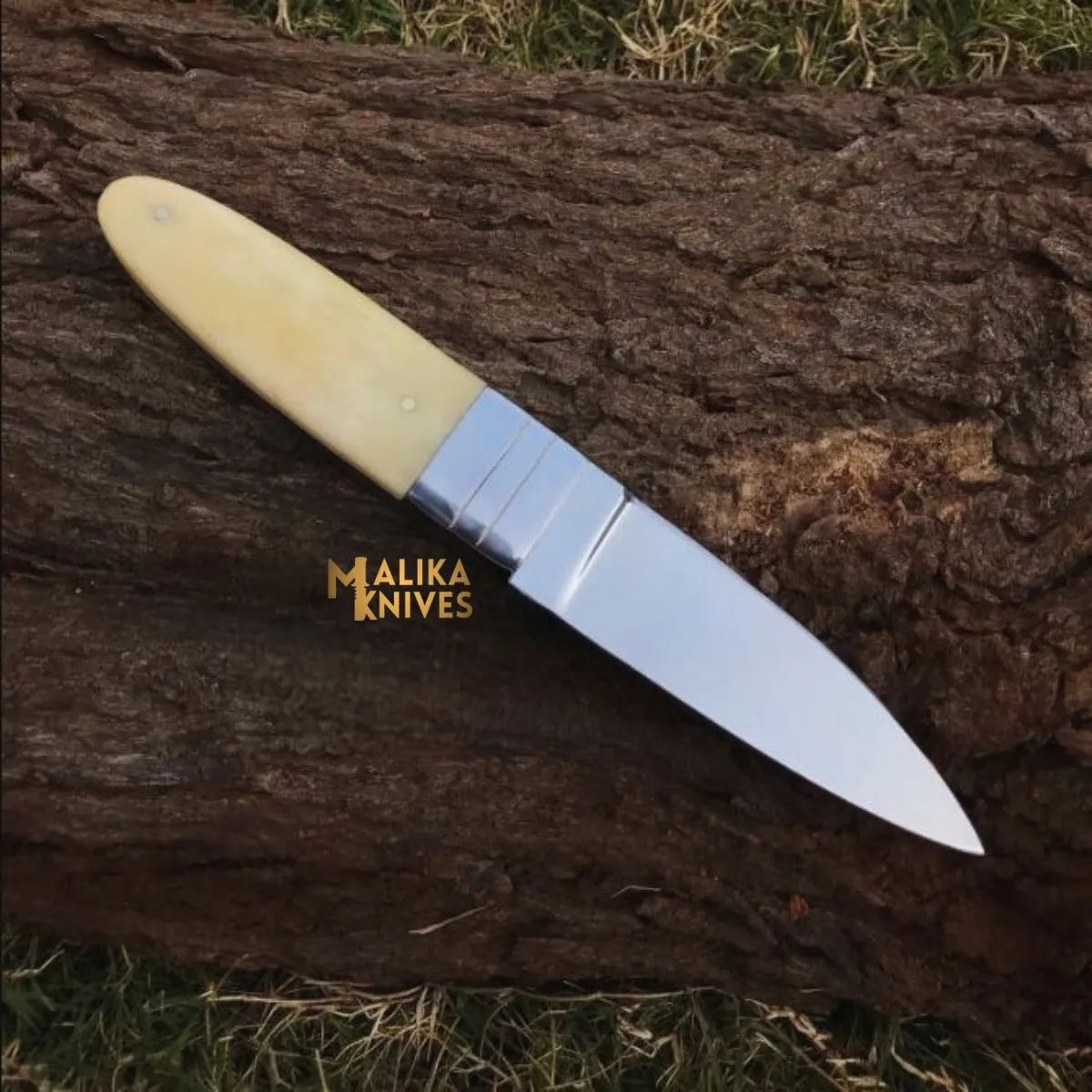 handmade d2 needle point hunting knife with camel bone handle on wooden surface