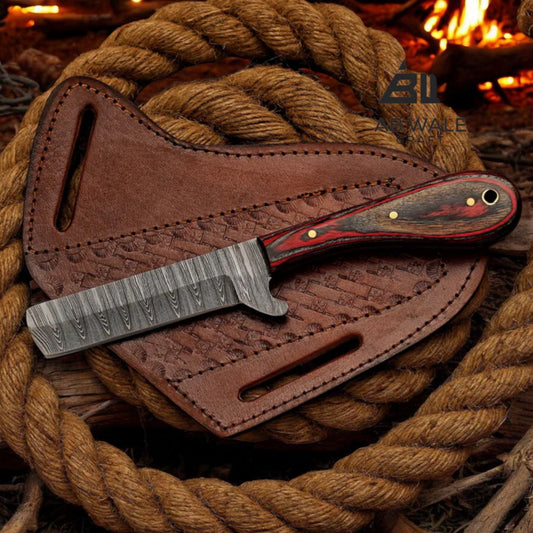 Damascus cowboy bull cutter knife with red pakka wood handle on a basket-tooled leather pancake sheath coiled in rope by a campfire.