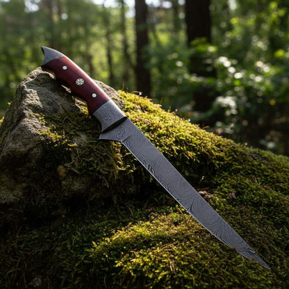 Close-up of Damascus fishing fillet knife blade with red micarta handle and Damascus bolster