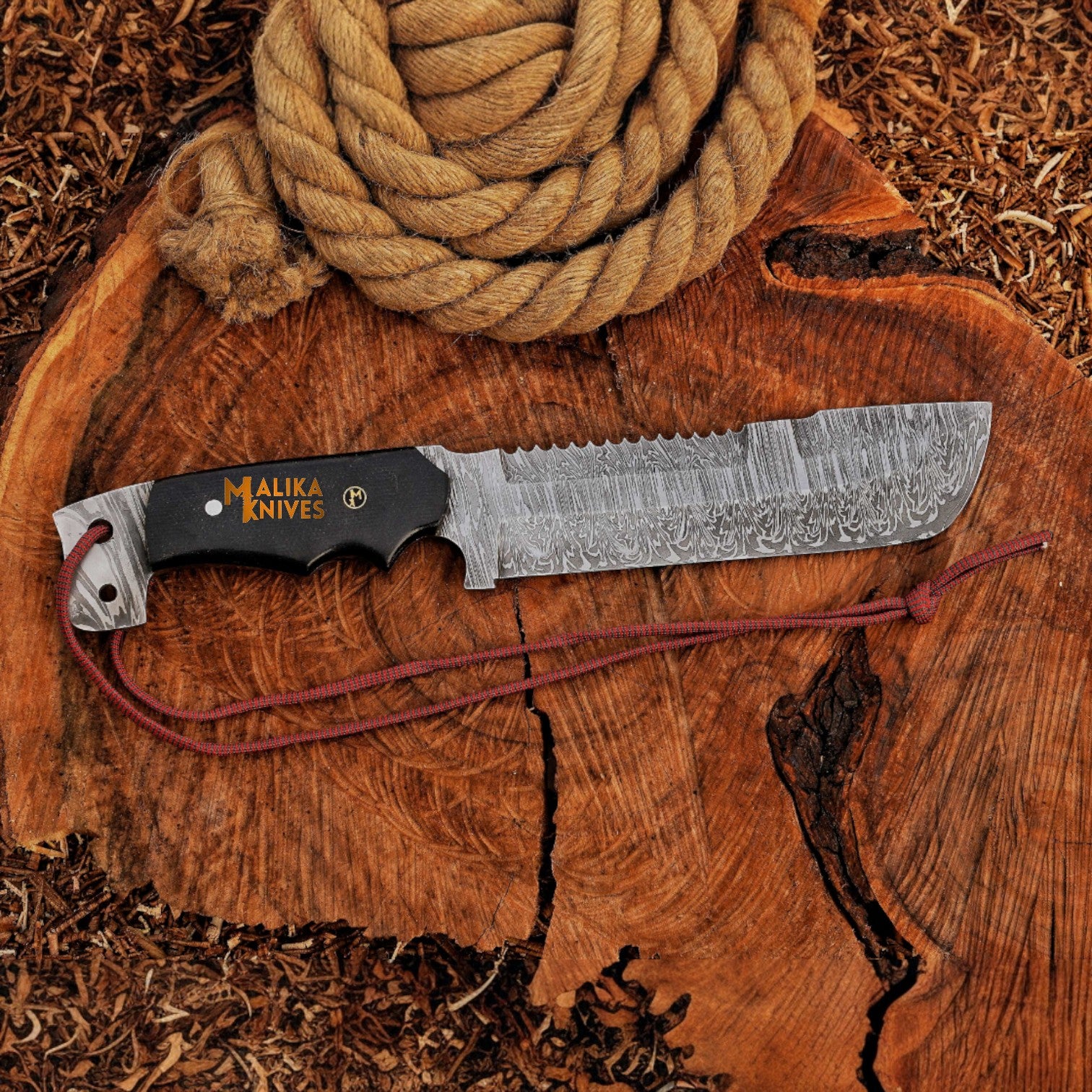 Close-up of fire-pattern Damascus steel blade on Punisher Bowie knife, showing detailed craftsmanship for survival, bushcraft, and display.