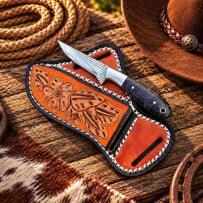 Cross-draw leather sheath with decorative patterned panels and contrasting white stitching
