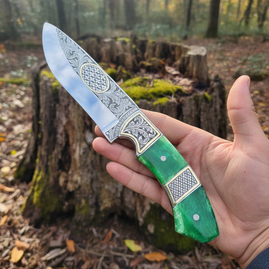 engraved d2 hunting knife with brass inlay and camel bone handle in hand