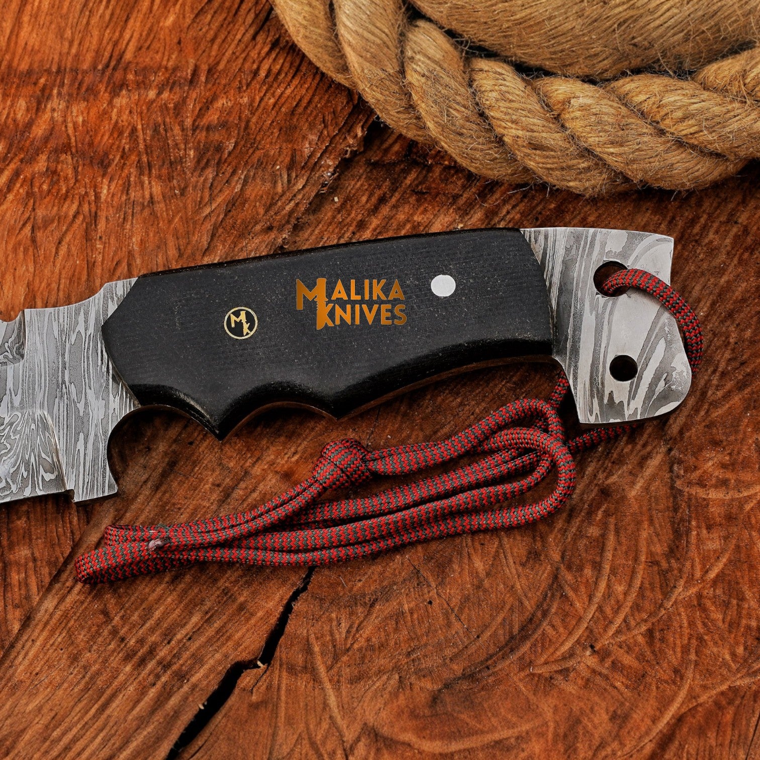 Ergonomic black G10 handle of Punisher Bowie knife with lanyard hole, full tang construction, and Damascus steel blade for hunting and tactical use.