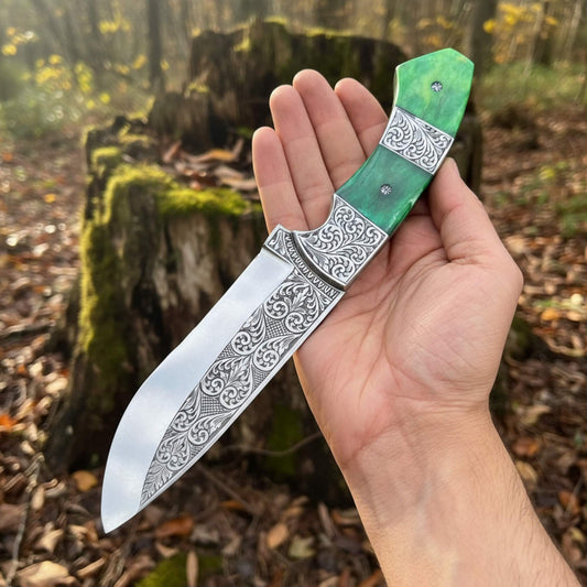 Hand holding a Hand engraved D2 Hunting knife with a green tinted camel bone handle in a forest setting.
