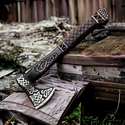 Viking battle axe with Norse knotwork engraved head and carved handle resting on a log