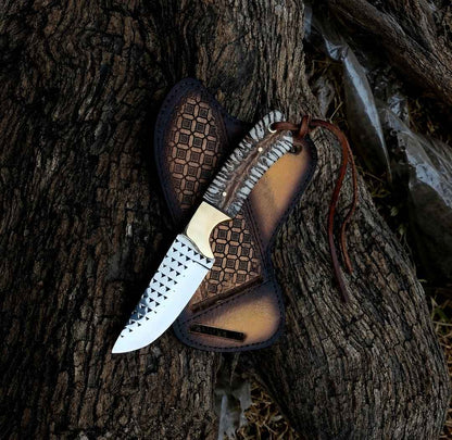 Rasp steel ranch knife with brass bolster and pine cone handle beside a crossdraw pancake sheath