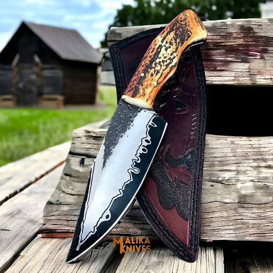 stag handle d2 hunting knife with full tang blade placed on wooden outdoor surface