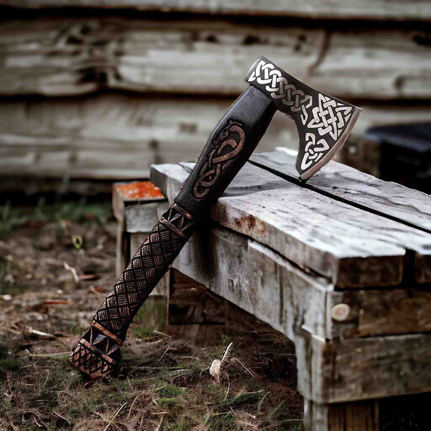 Hand-forged Viking bearded axe with carbon steel Celtic-engraved head on weathered wood