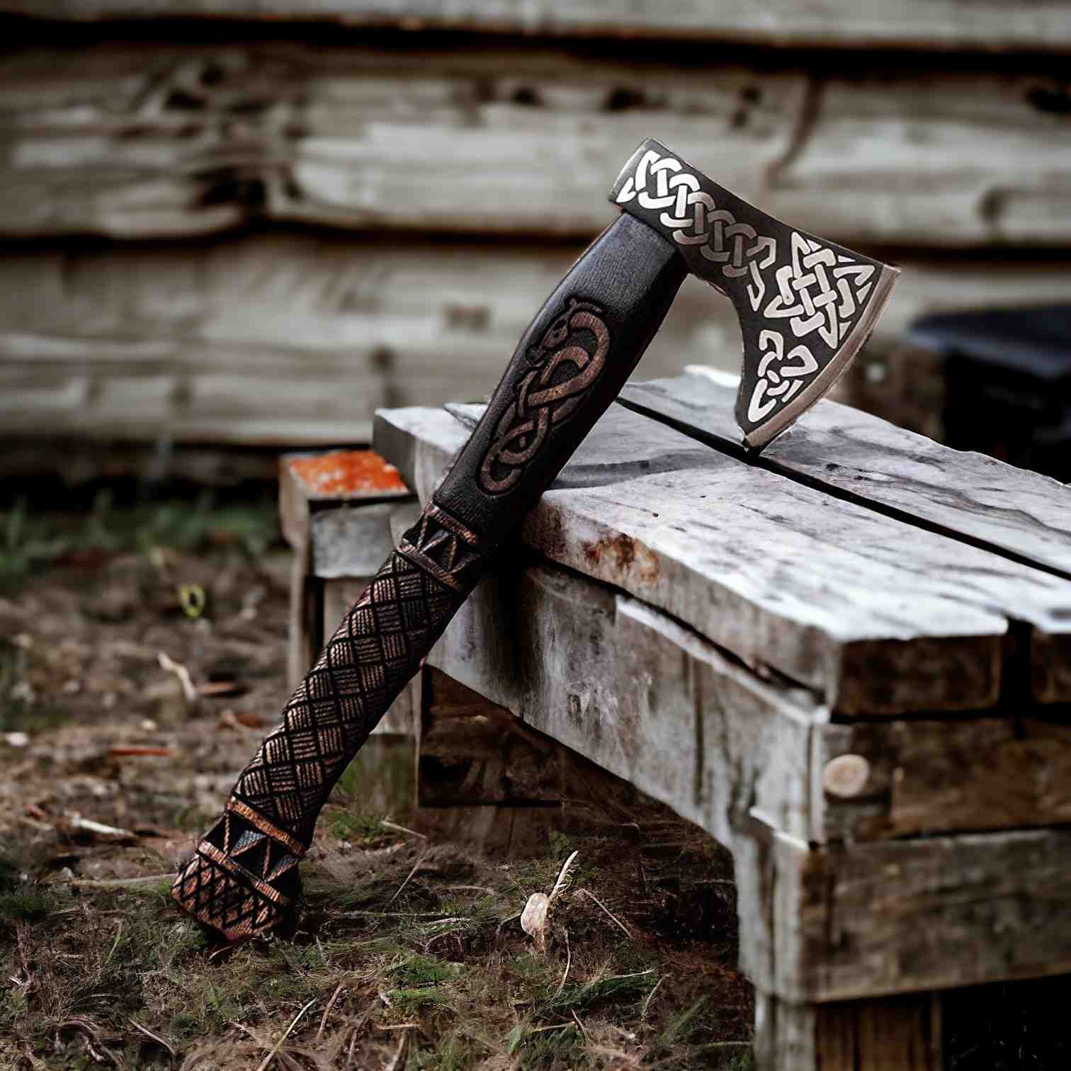 Hand-forged Viking bearded axe with carbon steel Celtic-engraved head on weathered wood