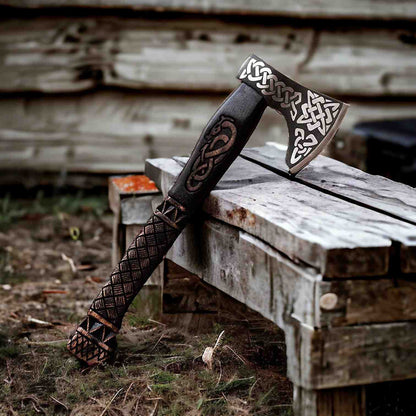 Hand-forged Viking bearded axe with carbon steel Celtic-engraved head on weathered wood