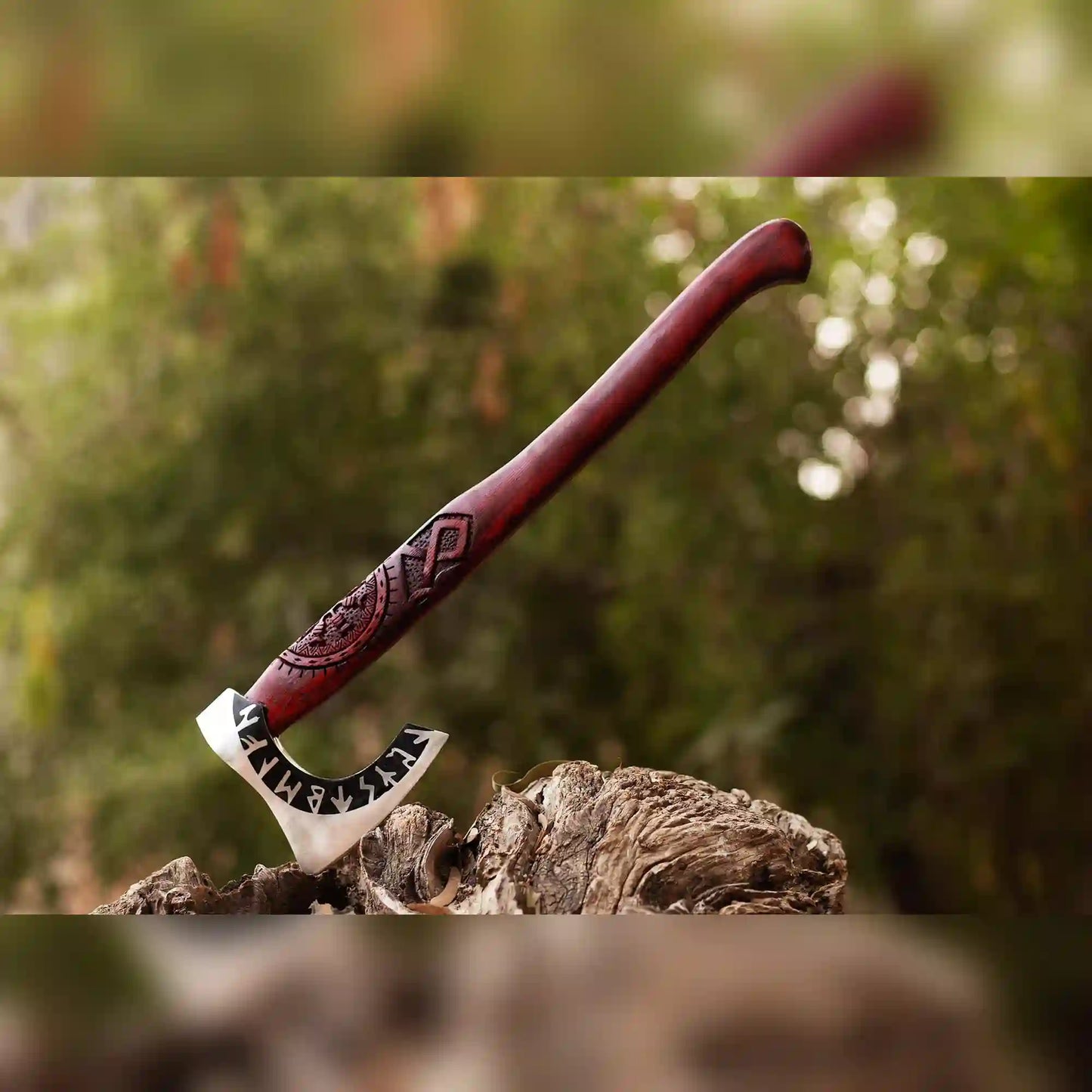 Runic Viking axe with 1075 steel head and carved red ash handle standing upright